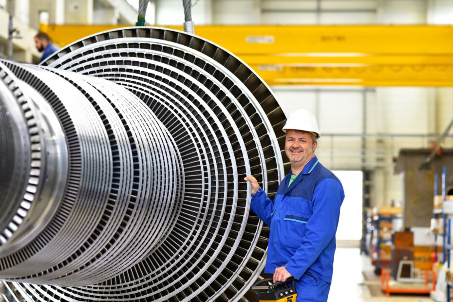 Worker smiling next to turbine