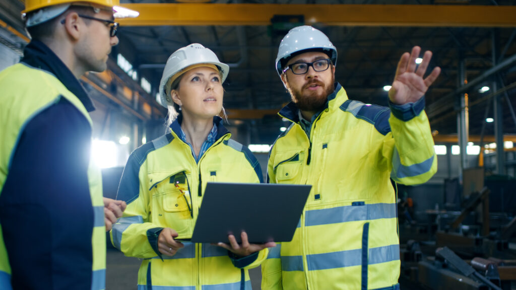 Male and Female Industrial Engineers Talk with Factory Worker